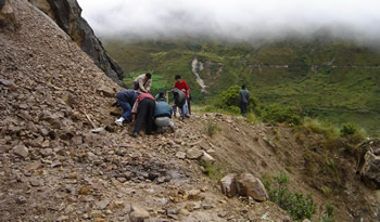 Carretera cortada, trabajando en un desprendimiento de tierras